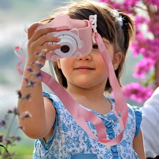 petite fille avec appareil photo enfant de chat dans un champ
