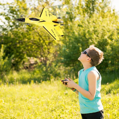 Garçon avec avion télécommandé de chasse jaune
