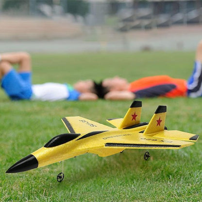 2 garçons se reposent à côté d'un avion télécommandé
