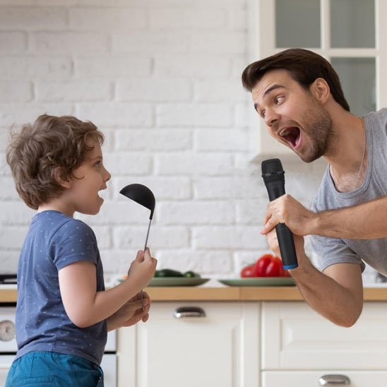 Père et fils chantent dans la cuisine avec  micro karaoké
