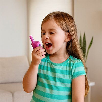 Fillette au salon avec un des talkies walkies rose