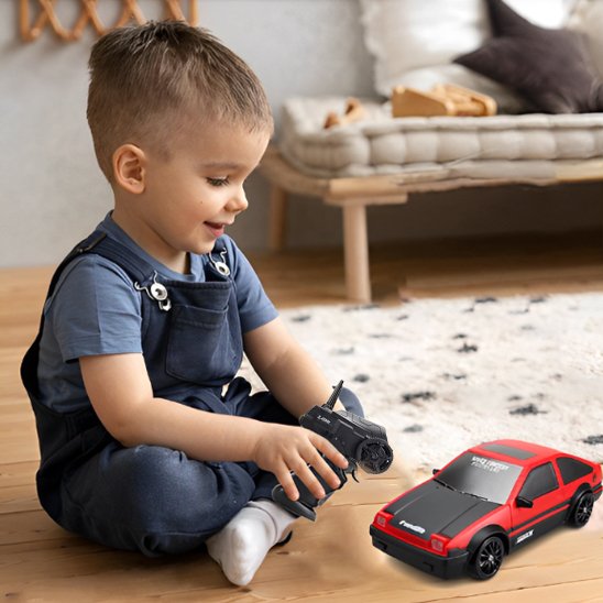 garçon avec voiture enfant télécommandée rouge