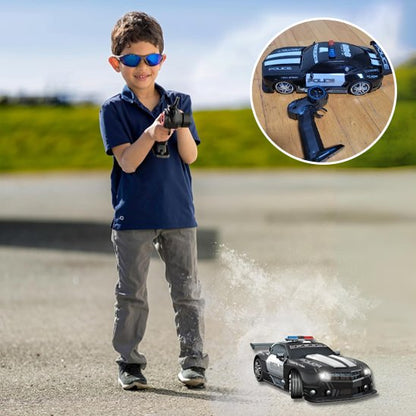 un garçon avec voiture télécommandée de police à l'extérieur